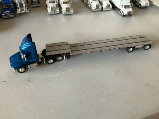 1/64 Dcp Blue International Cab With Air Dam And Spread Axle Step Deck Trailer