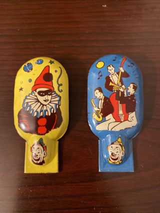 Two Vintage Tin Clicker Noisemaker Us Metal Toy Mfg Clown And Musicians.