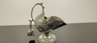 A Vintage Silver Plated Sugar Scuttle And Scoop With Embossed Patterns.